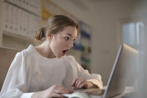 bulos informativos, una chica con cara de sorprendida mira a la pantalla de un ordenador