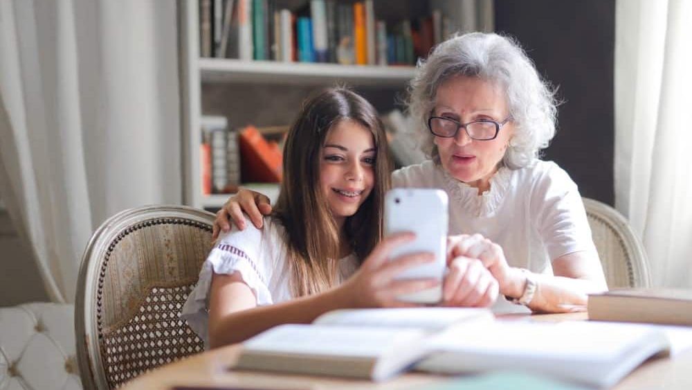 brecha digital, una abuela esta con su nieta interactuando con un movil