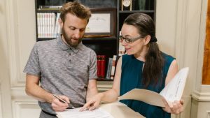 qué es un vacío legal, dos personas en una reunion explicando cosas sobre un documento que esta situado en una carpeta
