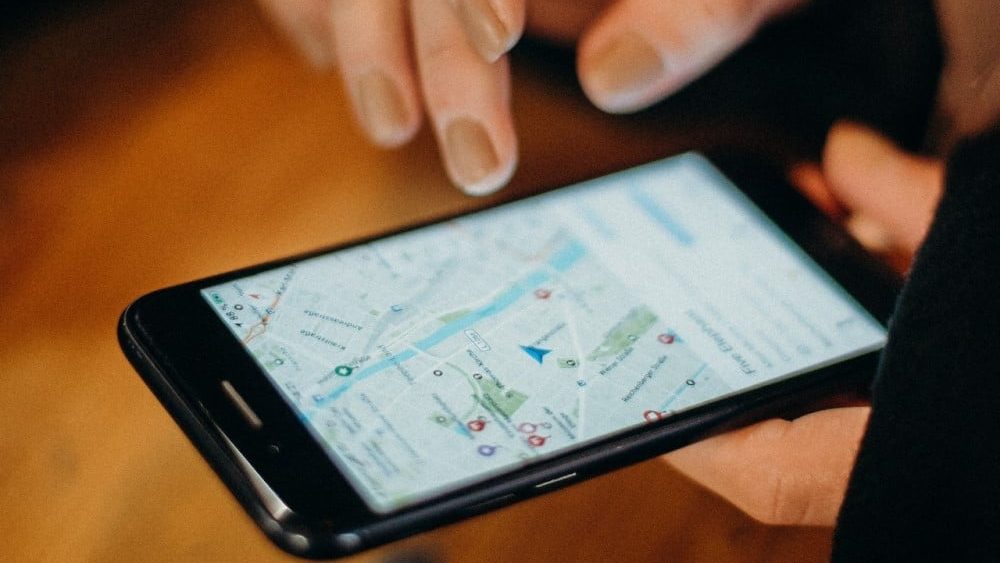 eliminar contribuciones de google, hay una persona sosteniendo un movil donde se ve una version antigua de google maps
