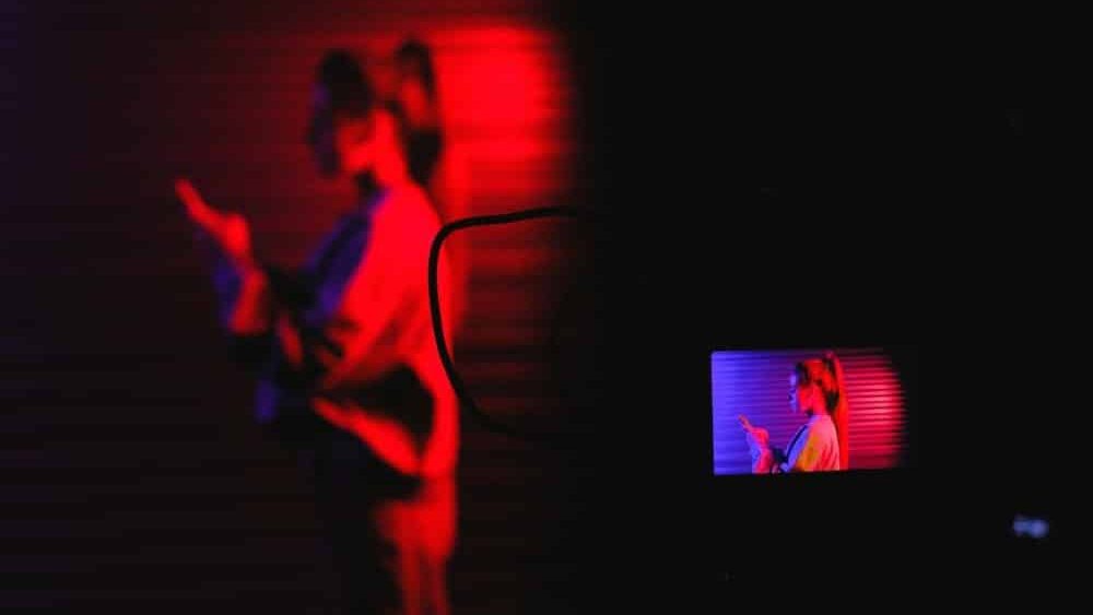 que es un deepfake, una imagen de una chica a la que le esta dando una luz roja y en primer plano se ve la pantalla de una camara reflex