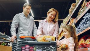reputacion de supermercados españoles, una familia de un hombre una mujer y una hija esta en el super contentos comprando comida, metiendolas en un carro.