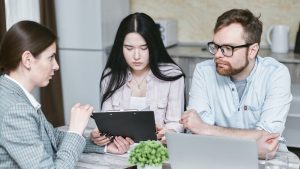 personas en una reunion de trabajo, se observa que hay dos personas atendiendo la explicacion de otra