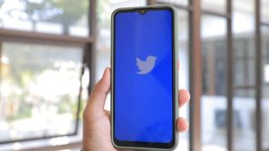 persona coge un movil con el logo de twitter