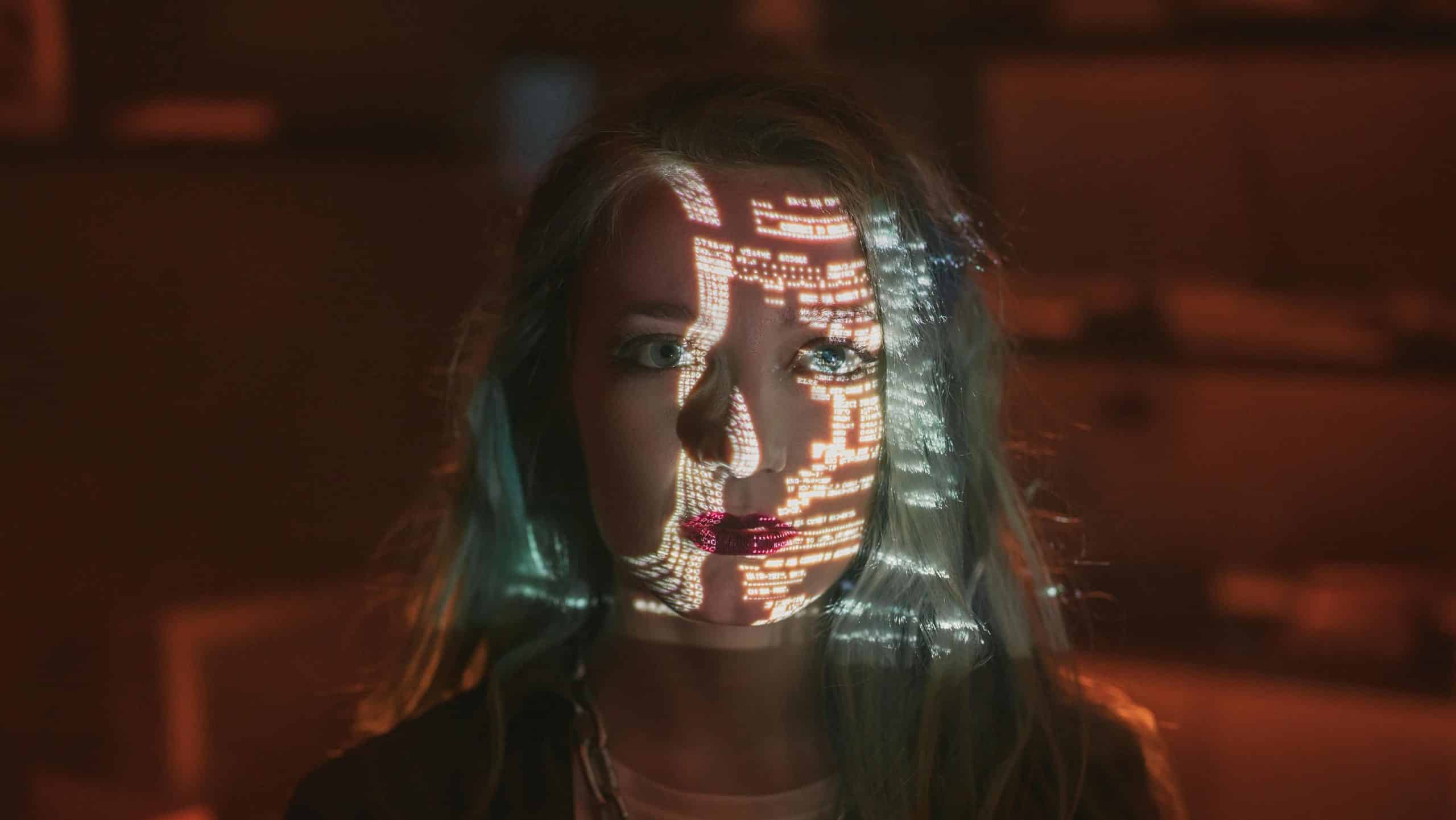 chica mira hacia un lado, tiene numeros blancos proyectados en la cara, el fondo es rojo