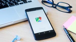 Phone resting on a laptop with Google Maps logo