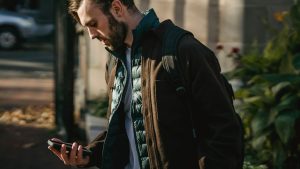 persona mira el movil en movimiento en la calle, estilo urbano