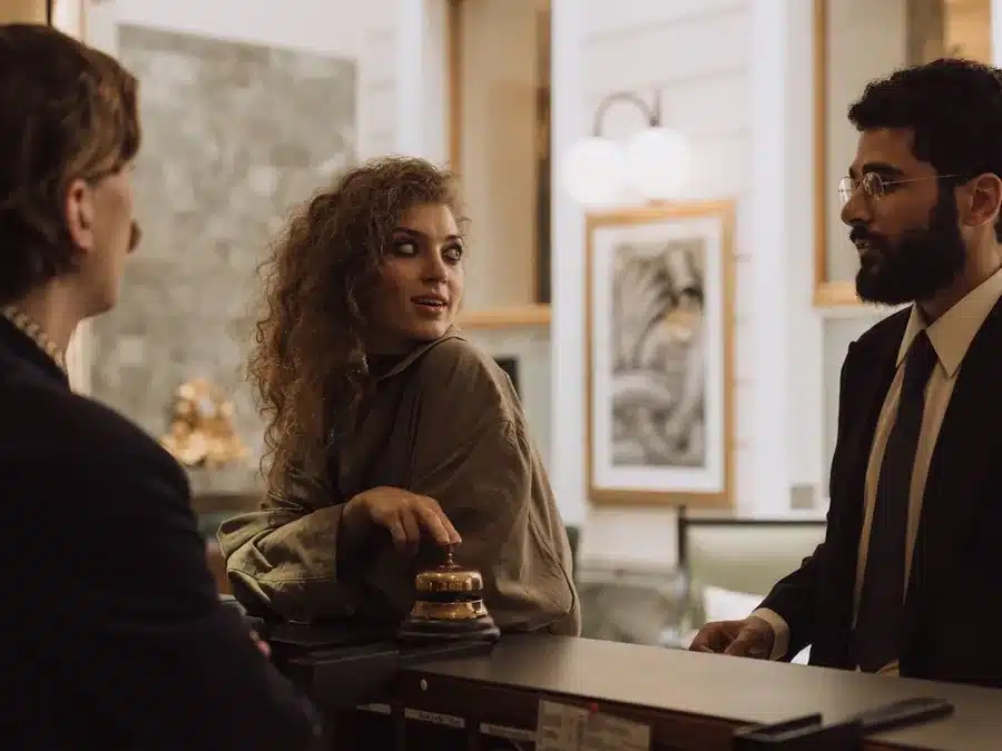 Recepción de hotel atendiendo a unos huéspedes: gestión de reseñas para hoteles y turismo