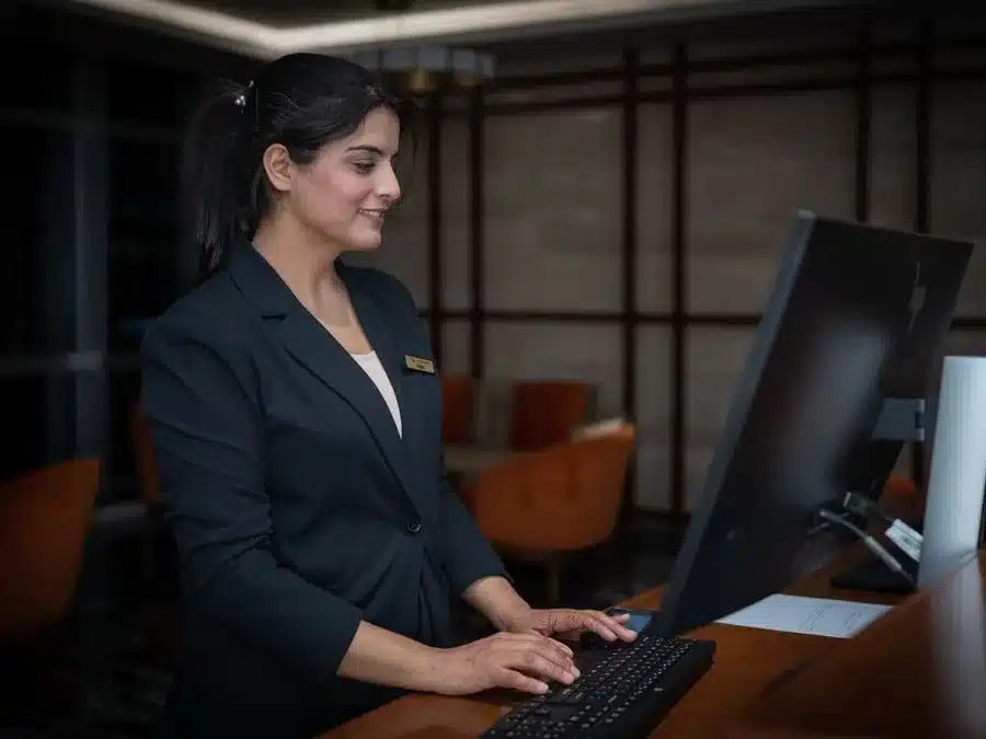 Recepcionista de hotel gestionando reservas: gestión de reseñas para hoteles y turismo