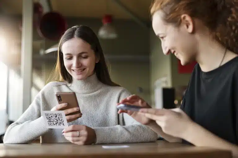 Clienta escaneando con el móvil el código QR para dejar una reseña en una cafetería
