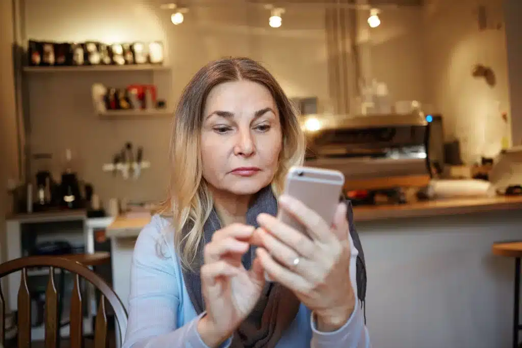 Dueña de una cafetería revisando en el móvil las reseñas de Google de su negocio