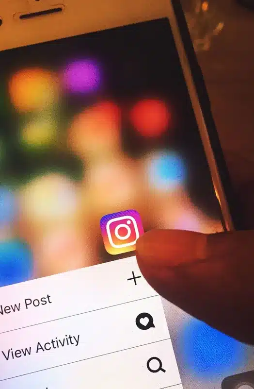 Hand opening a social network on a phone: where a fake profile operates