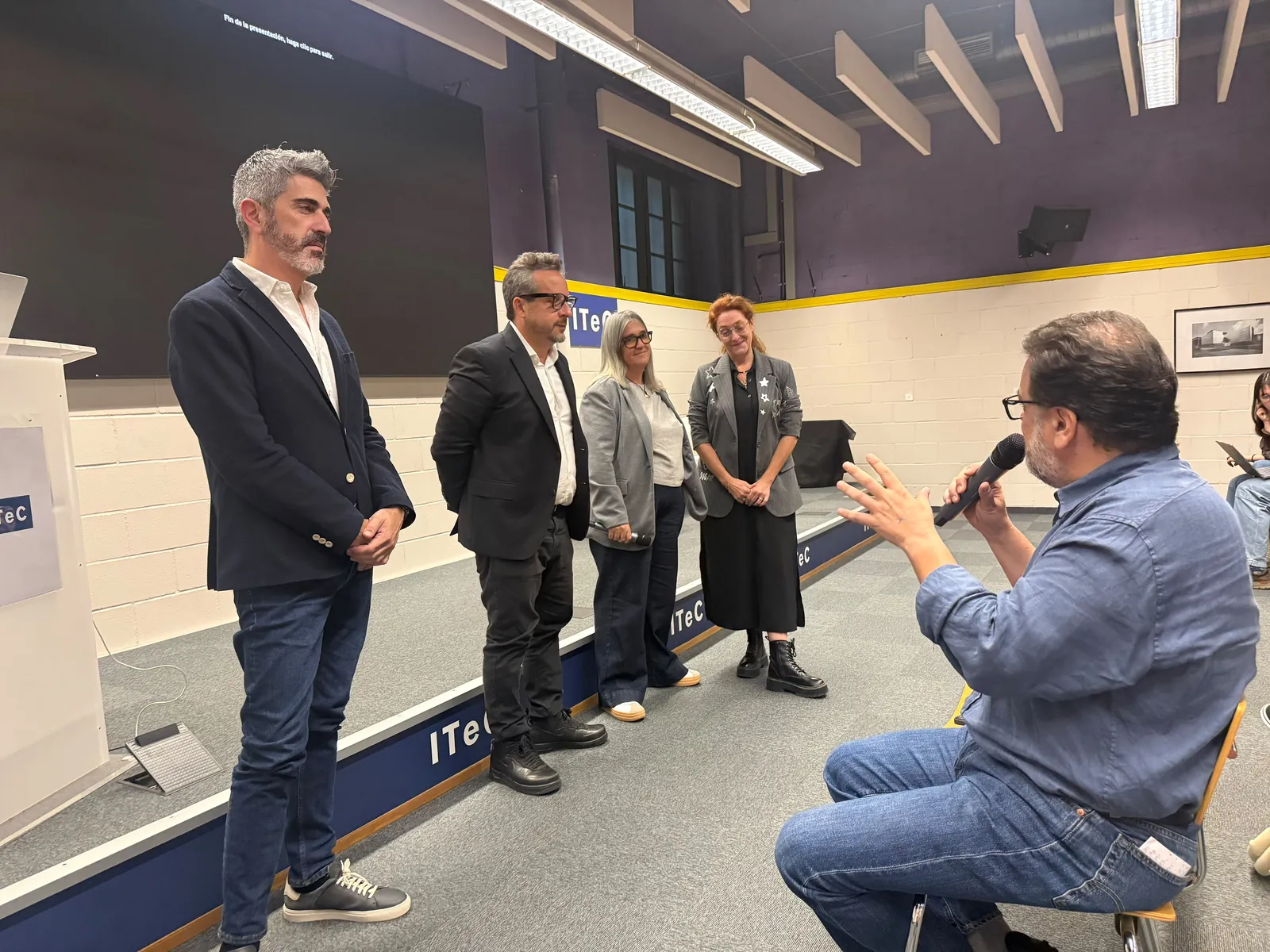 Asistente preguntando a los ponentes durante el coloquio del seminario